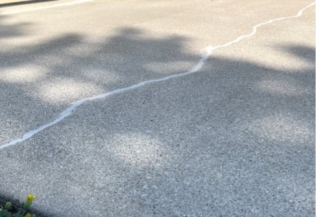 An example of a cracked driveway filled with a concrete crack sealant in Indianapolis.