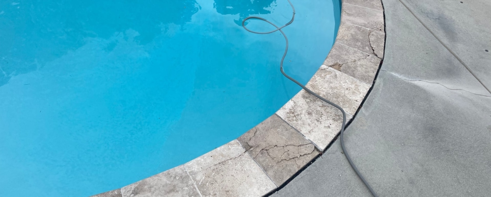 Concrete pool deck with cracks around edge