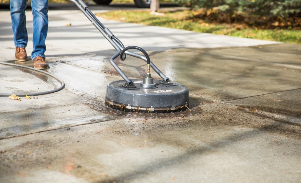 A LevelUp technician power washing a concrete driveway