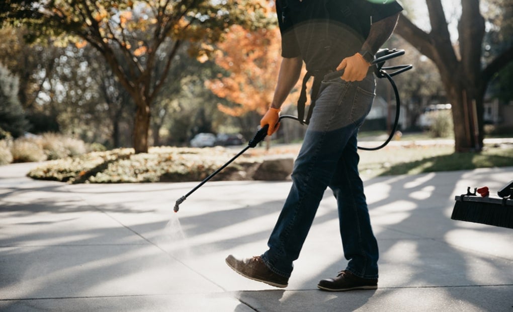 A LevelUp technician spraying SealantPro onto a concrete driveway