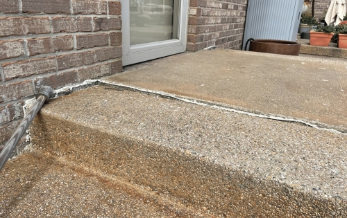 Cracked and sunken concrete step before repair